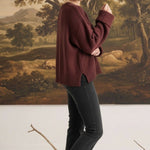 graced cocoa brown ribbed cuff sweater worn by a woman with black jeans and sneakers in a studio setting