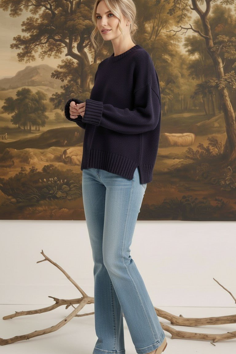 graced navy ribbed cuff sweater worn by a model with light blue jeans in a studio setting