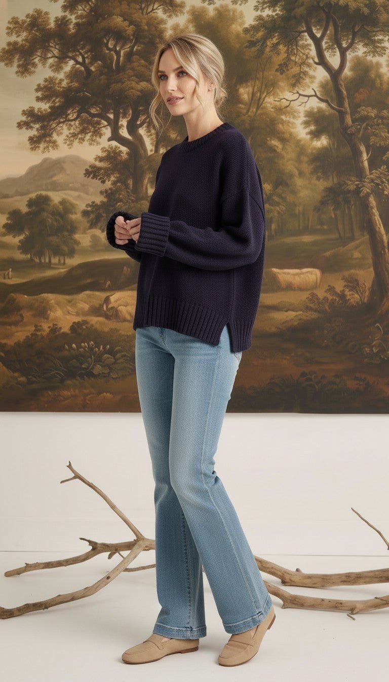 graced navy ribbed cuff sweater worn by a model with light blue jeans in a studio setting