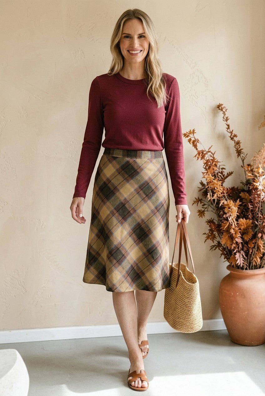 graced wine round neck knit top worn by a woman with a plaid midi skirt and straw tote bag