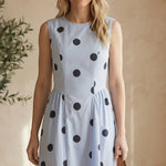 Navy blue sleeveless polka dot midi dress by Klesis, featuring a fitted waist and flowing skirt, perfect for summer occasions.