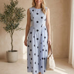 Klesis sleeveless navy blue polka dot midi dress with a fitted waist and flowing skirt, perfect for summer or casual occasions.