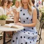 Navy blue sleeveless polka dot midi dress by Klesis, featuring a relaxed fit and classic polka dot pattern.