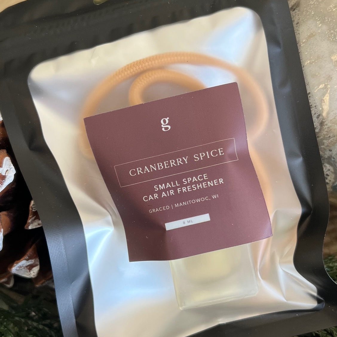 Graced small space air freshener in cranberry spice scent, compact home fragrance with a sleek design and vibrant cranberry spice theme.