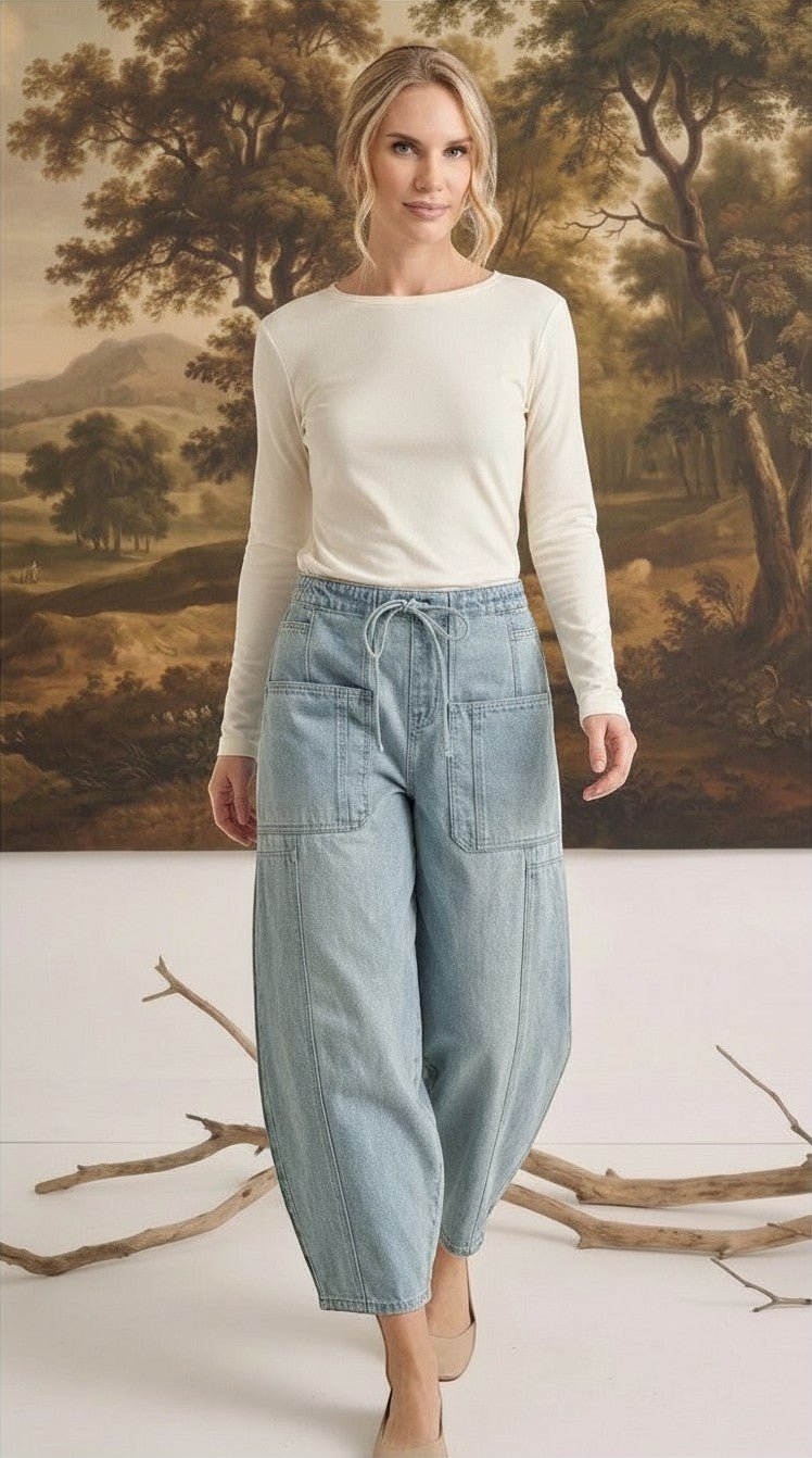 Model wearing graced soft denim barrel pants in light wash cotton with a drawstring waist and large patch pockets.