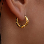 Gold Source Huggies earrings by ALCO, stylish jewelry accessory with a sleek hoop design.