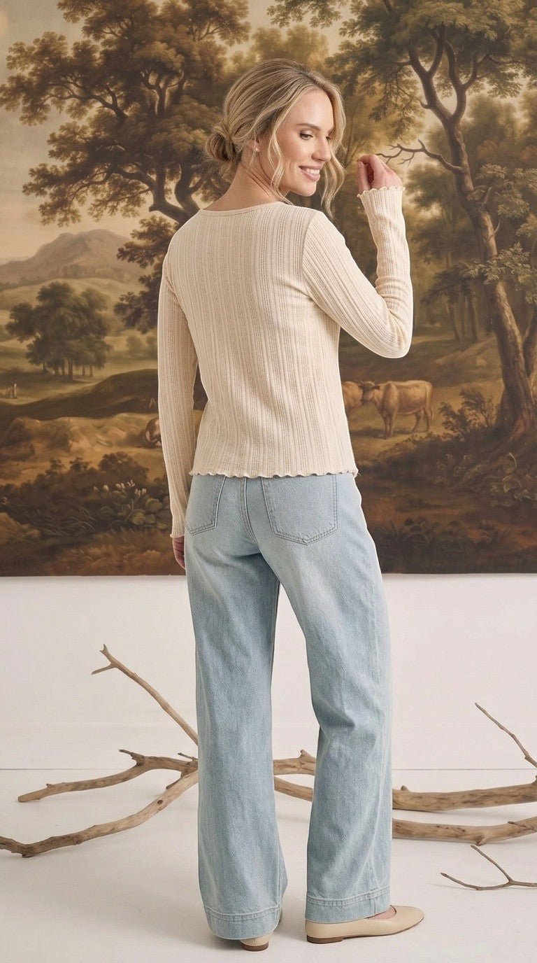 graced textured ribbed long sleeve top in cream worn by a woman with light blue jeans, back view