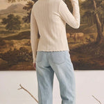 graced textured ribbed long sleeve top in cream worn by a woman with light blue jeans, back view