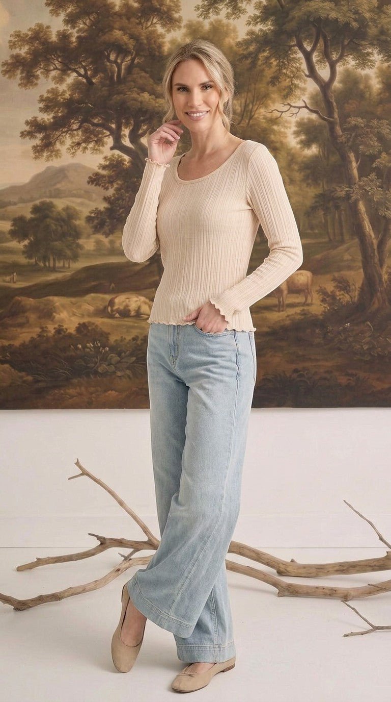 graced textured ribbed long sleeve top in beige with lettuce edge cuffs worn by a woman with light blue jeans