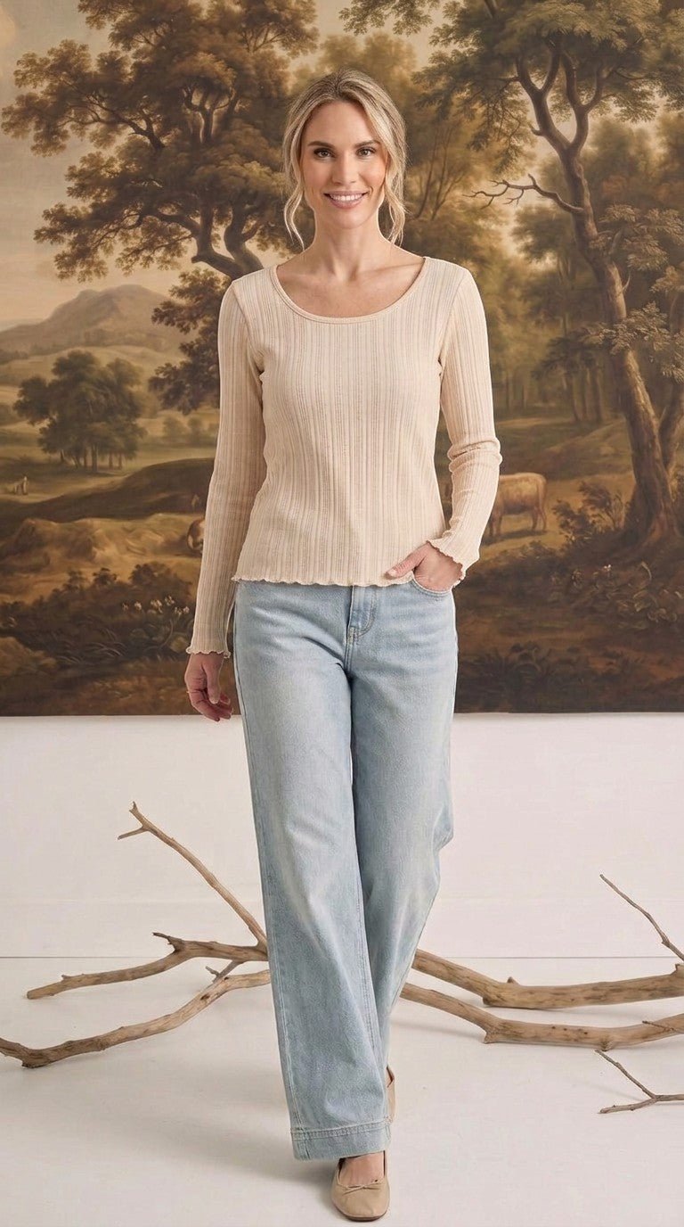 graced textured ribbed long-sleeve top in beige worn by a woman with light-wash denim jeans