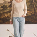 graced textured ribbed long-sleeve top in beige worn by a woman with light-wash denim jeans