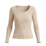 graced beige long sleeve top featuring a textured ribbed knit fabric with a scoop neckline and lettuce edge hem