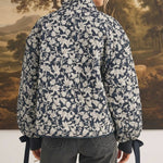 Back view of a model wearing the graced Alexis floral quilted cotton jacket with bow details on the sleeve cuffs.