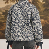 Back view of a model wearing the graced Alexis floral quilted cotton jacket with bow details on the sleeve cuffs.