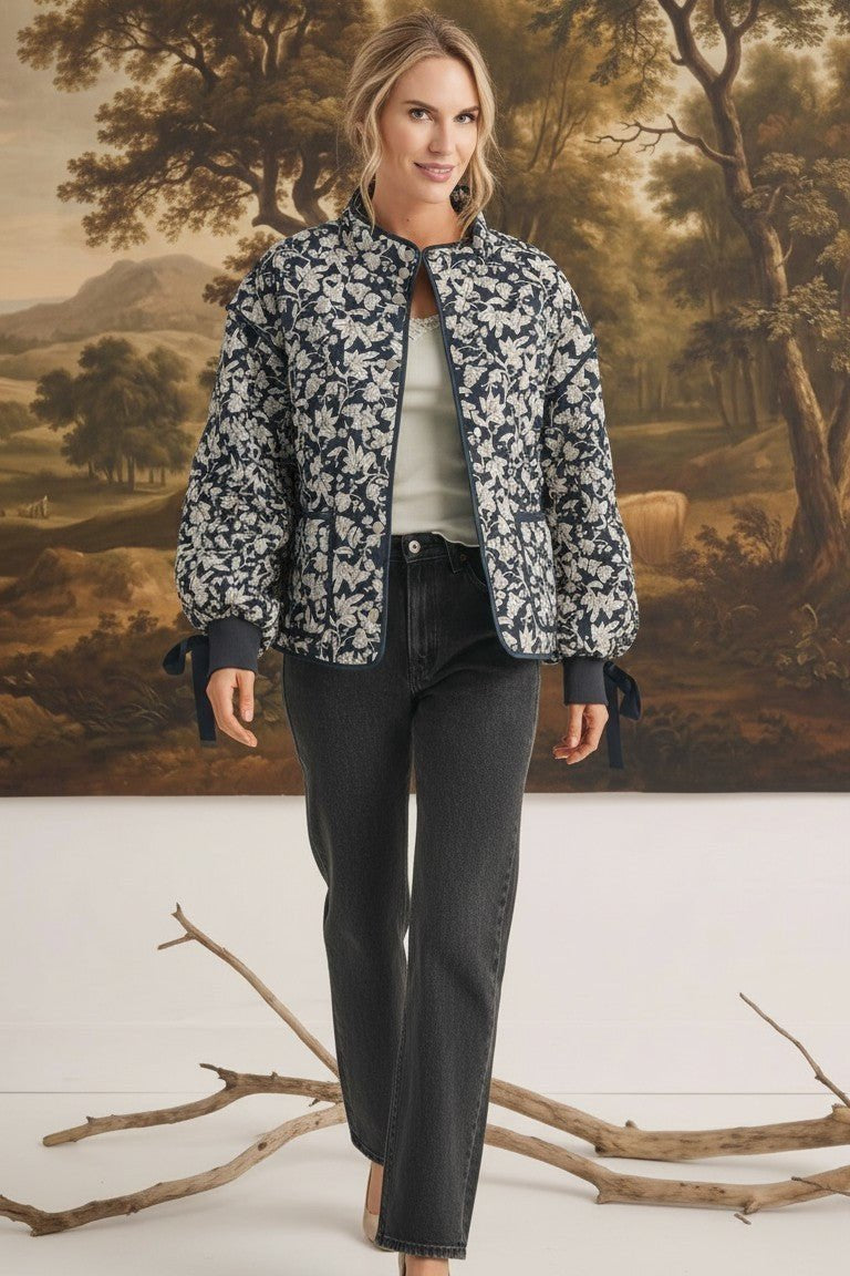 graced Alexis floral quilted cotton jacket with sleeve bows worn by a model in front of a landscape painting