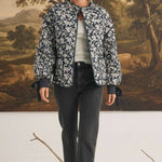 graced Alexis floral quilted cotton jacket with sleeve bows worn by a model in front of a landscape painting