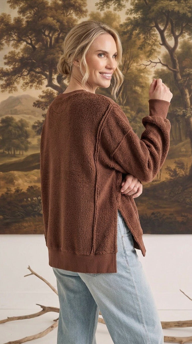 graced The Ashley oversized chocolate brown fleece top with side slits worn by a woman against a landscape backdrop