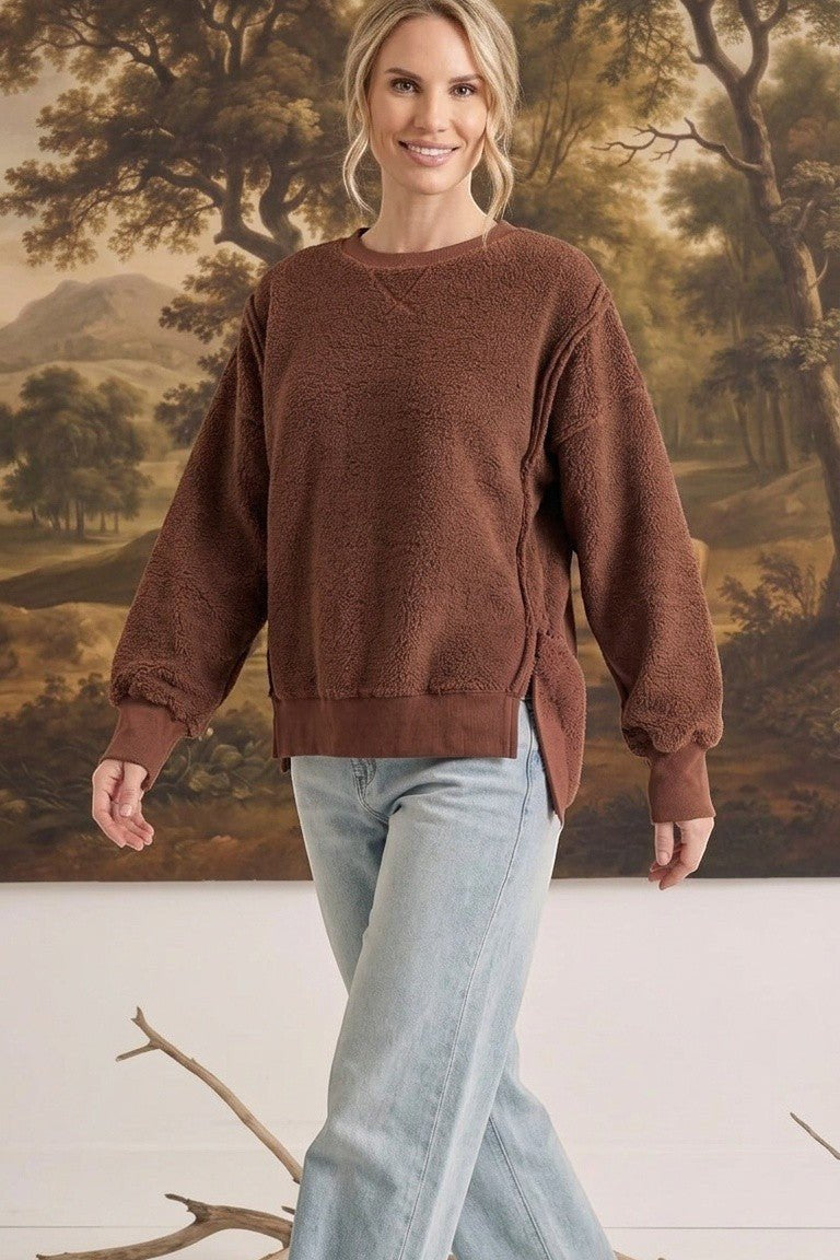 graced The Ashley oversized chocolate brown brushed fleece top with side slits worn by a blonde model with jeans