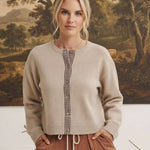 graced Baylie cardigan in beige with brown gingham trim along the button placket worn by a woman
