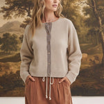 graced Baylie cardigan in beige with brown gingham trim along the button placket worn by a model
