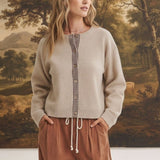 graced Baylie cardigan in beige with brown gingham trim along the button placket worn by a model