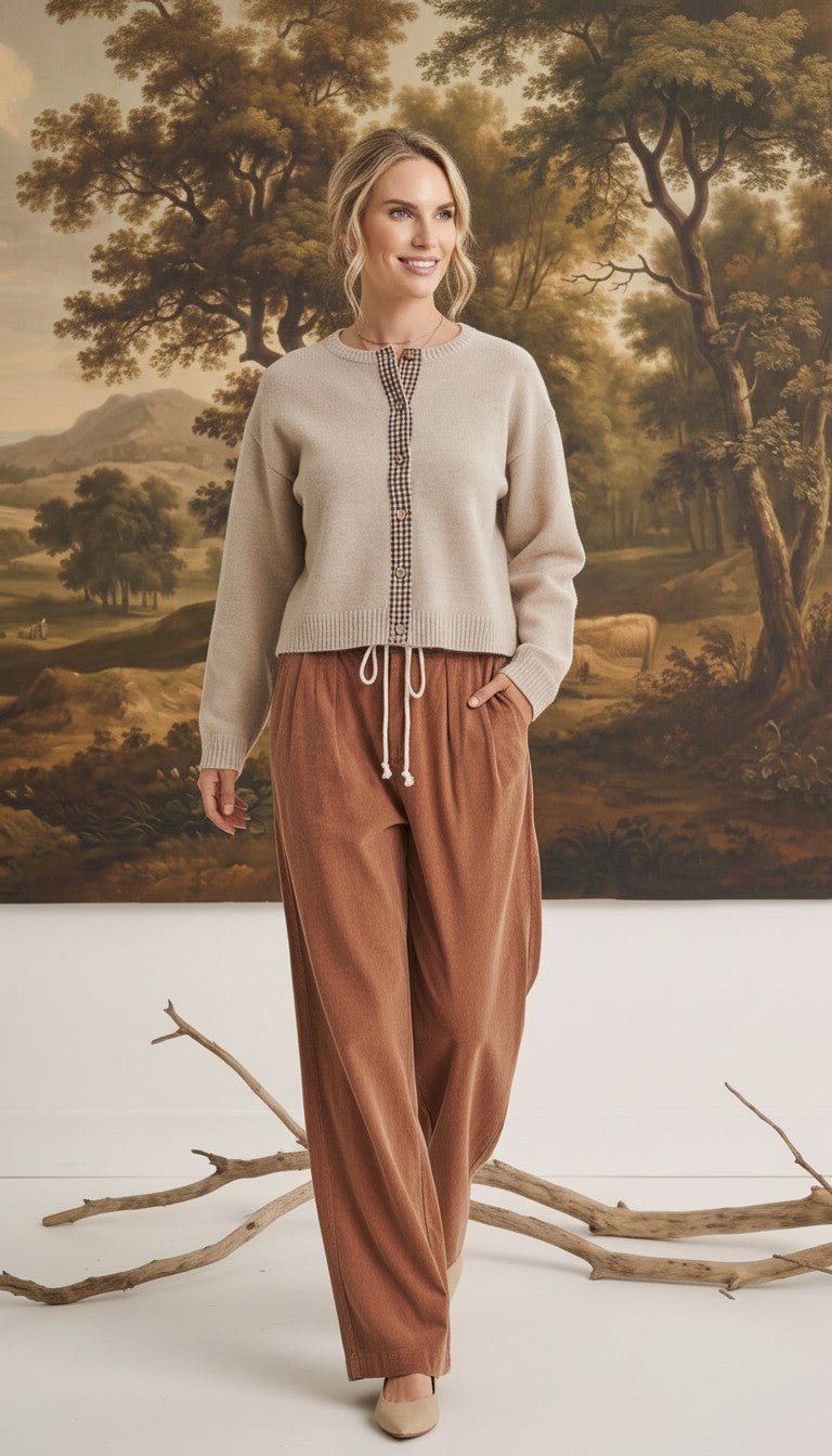 graced Baylie cardigan in beige with gingham trim worn by a model with brown corduroy pants in a studio setting