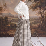 graced Beatrice midi skirt in plaid cotton with a smocked waist, worn with a cream cardigan and tan heeled boots