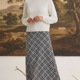 graced The Beth plaid midi skirt in black and white worn with a cream sweater by a model in a studio setting