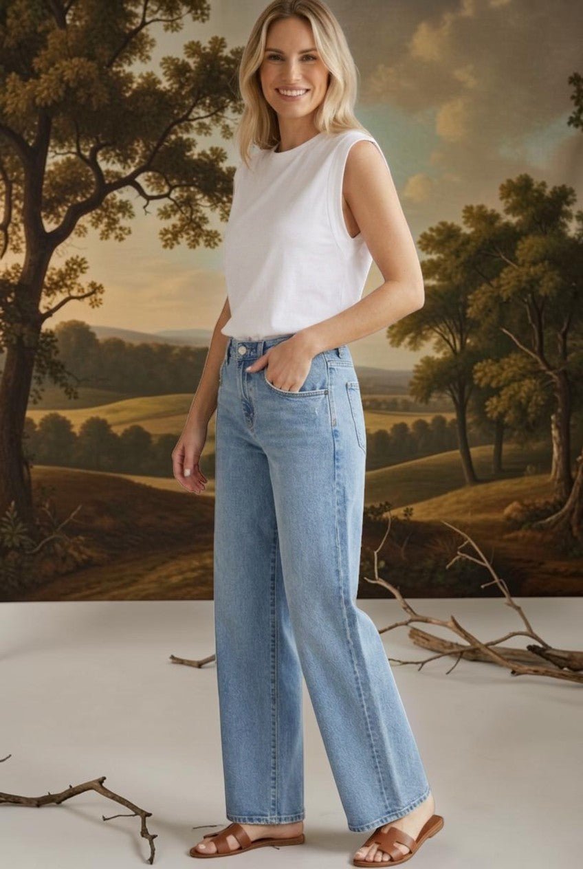 A woman wearing graced Blaine high rise straight leg jeans in a light blue wash with a white sleeveless top.