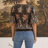 graced Brenda floral top in brown with puff sleeves and ribbed waist, worn by a woman from the back view
