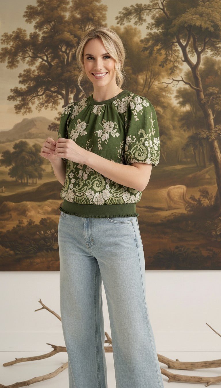 Model wearing graced Brenda olive green floral top with puff sleeves and ribbed waist, paired with light wash jeans.