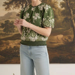 Model wearing graced Brenda olive green floral top with puff sleeves and ribbed waist, paired with light wash jeans.