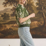 graced Brenda floral top in olive green with puff sleeves and ribbed waist, worn by a woman with light blue jeans