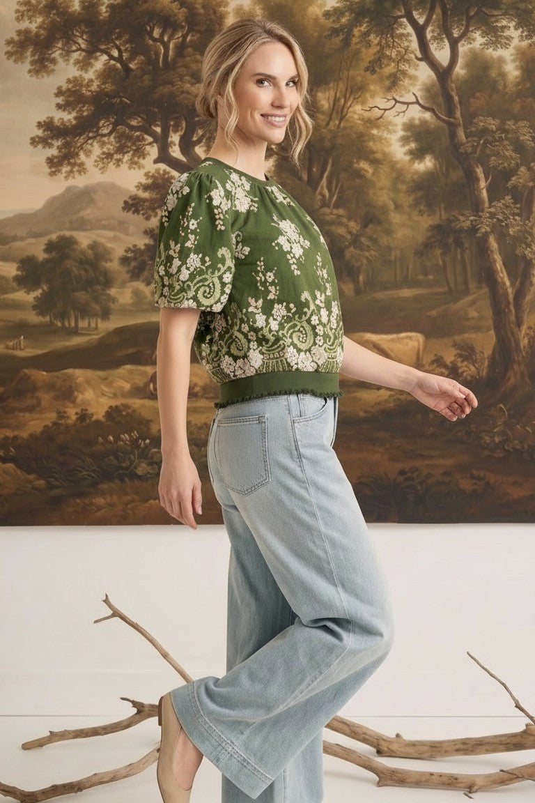 graced Brenda floral top in olive with puff sleeves and ribbed waist, worn by a model with light wash jeans