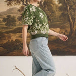 graced Brenda floral top in olive with puff sleeves and ribbed waist, worn by a model with light wash jeans
