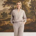 graced Brooklyn Rib quarter-zip sweater and matching joggers in heather taupe worn by a smiling woman