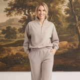 graced Brooklyn Rib quarter-zip sweater and matching joggers in heather taupe worn by a smiling woman