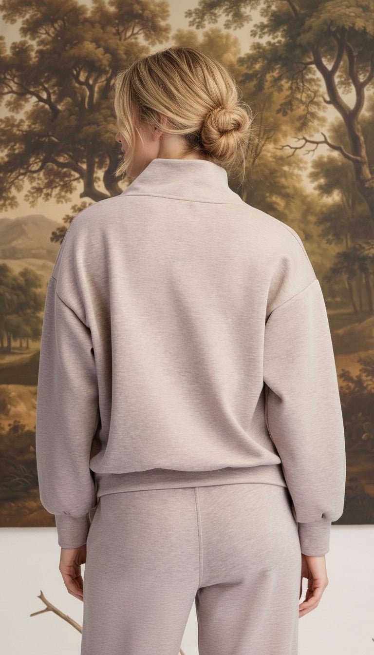 Back view of a woman wearing a graced heather taupe ribbed quarter-zip sweater with a relaxed fit