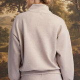 Back view of a woman wearing a graced heather taupe ribbed quarter-zip sweater with a relaxed fit