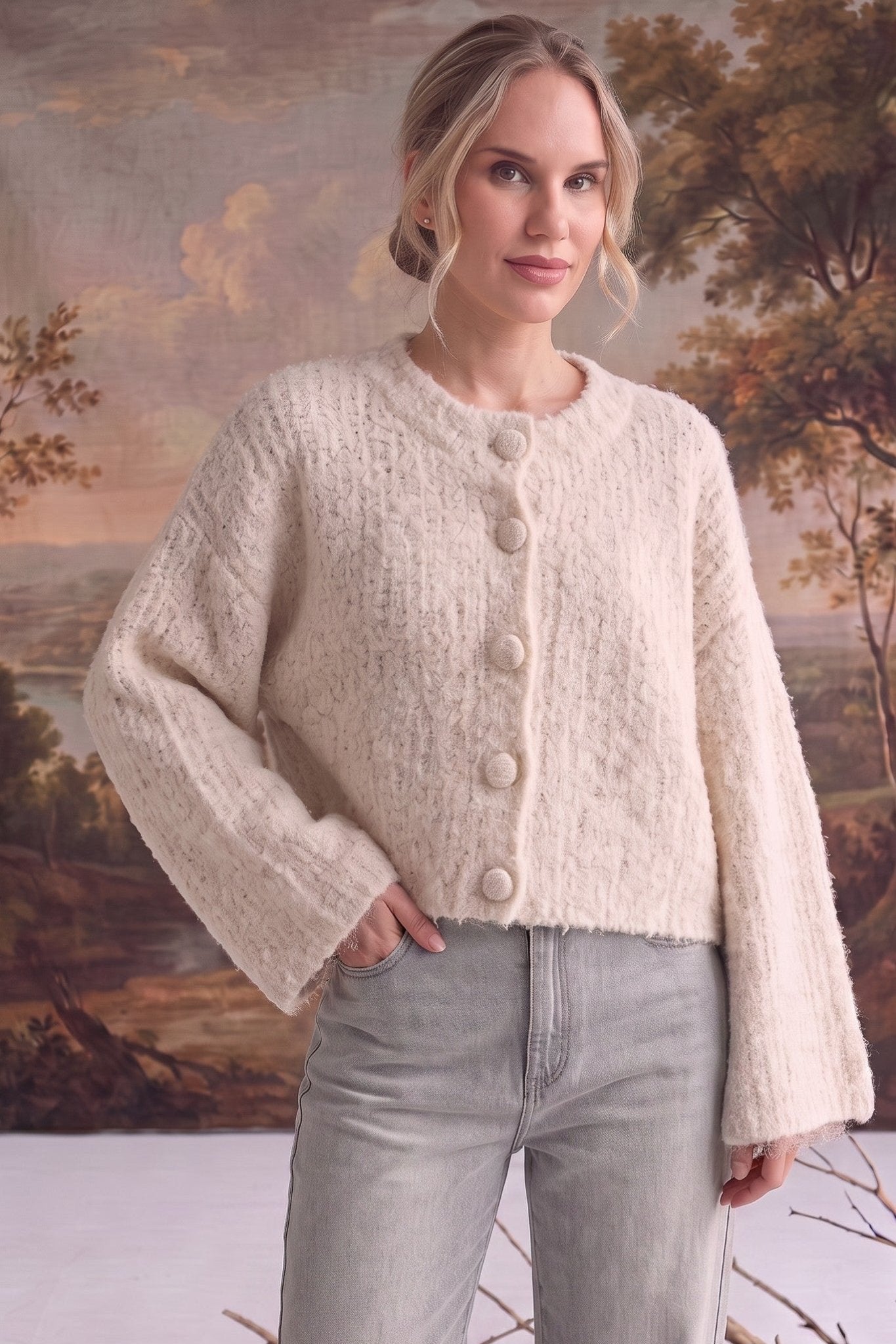 graced The Callie fuzzy knit cardigan in cream with a round neckline and button front, worn by a model.