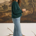 Model wearing graced The Carley Mallard Sweater in forest green with light wash jeans and beige loafers