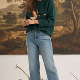 graced Carley Mallard sweater in forest green featuring a mallard duck design, worn with light wash jeans