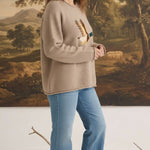 graced Carley Mallard sweater in mocha featuring a mallard duck graphic, worn by a model with blue jeans