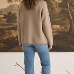 Model wearing a mocha Carley Mallard sweater by graced with blue jeans and loafers, back view