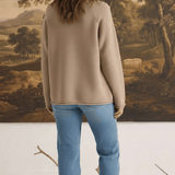 Model wearing a mocha Carley Mallard sweater by graced with blue jeans and loafers, back view