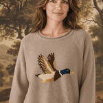 graced Carley Mallard sweater in mocha featuring a flying duck intarsia knit design worn by a woman