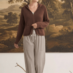 Model wearing graced The Carly Mixed Stripe wide leg pants with a brown zip-up hoodie in a studio setting