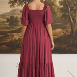 Back view of a woman wearing a graced Celeste puff sleeve midi dress in deep burgundy with a smocked bodice.