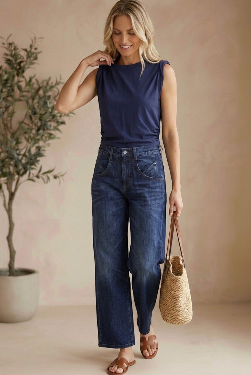 graced The Cinch Side Top in navy cotton worn by a blonde model with wide-leg jeans and a straw tote bag