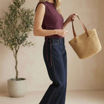 graced The Cinch Side Top in winetasting cotton with side tie detail worn by a smiling woman with dark denim jeans